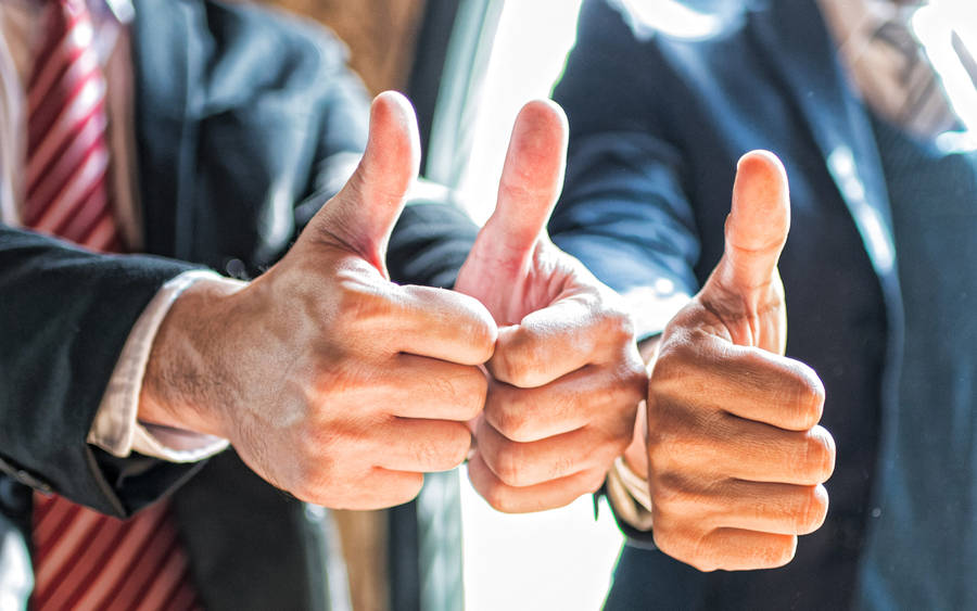 Enthusiastic Team Giving Thumbs-up In Success Wallpaper