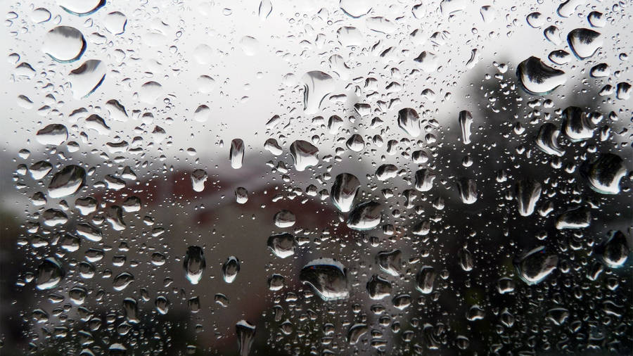 Falling Raindrops On Transparent Glass Pane Wallpaper