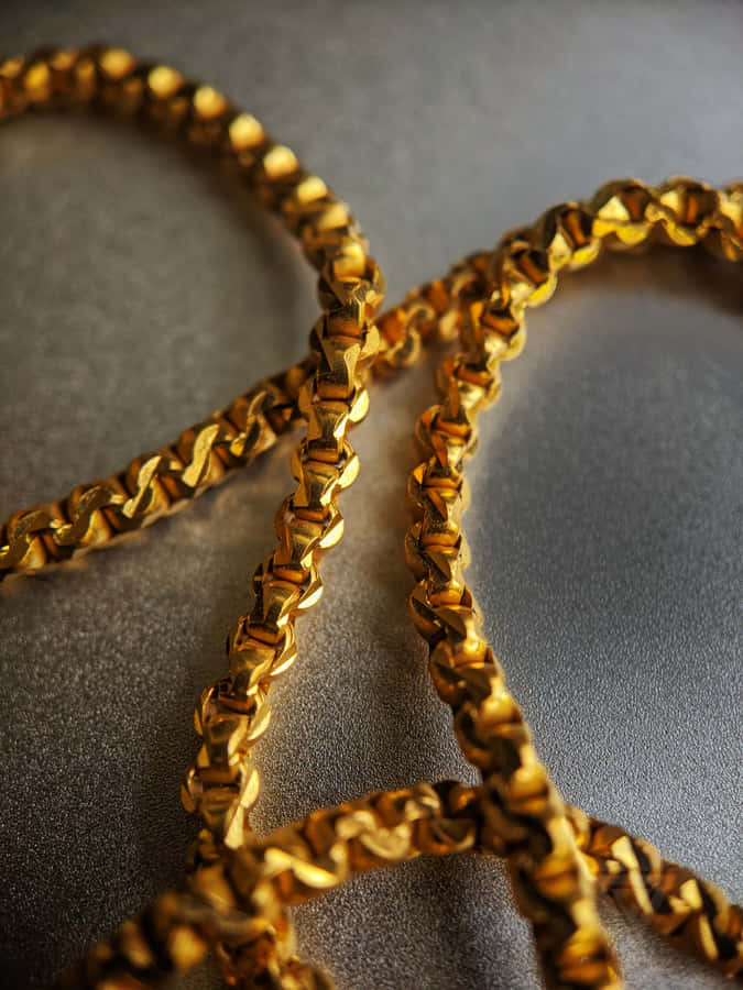Gold Chain On A Silver Surface Wallpaper
