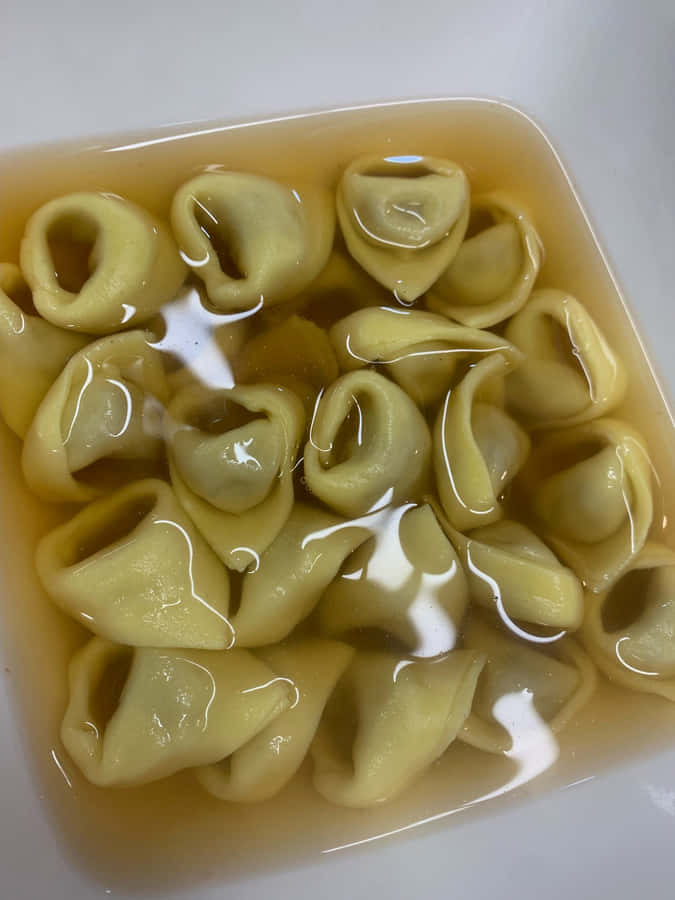 Gourmet Tortellini In Brodo In A Square Bowl Wallpaper