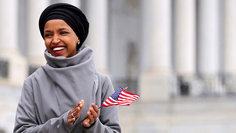 Ilhan Omar Holding A Tiny Flag Wallpaper