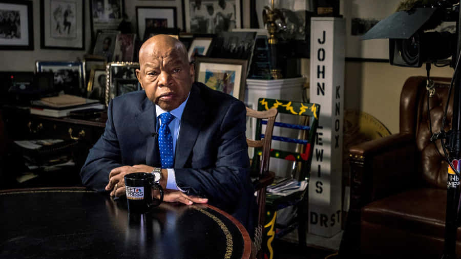 John Lewis Engaged In Deep Thought At A Meeting Table Wallpaper
