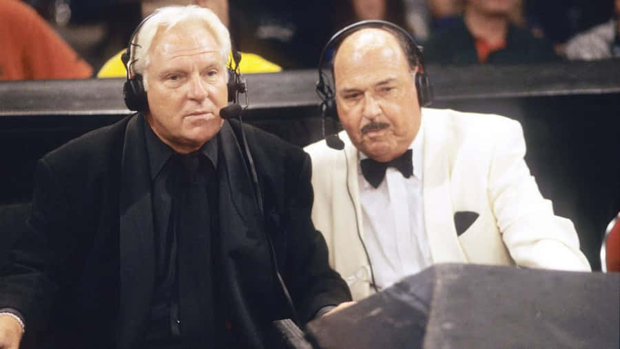 Legendary Wrestling Commentators At Desk Wallpaper