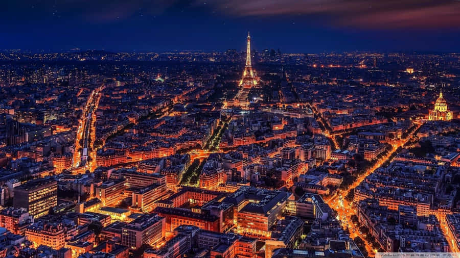 Majestic Eiffel Tower Illuminated At Night In Paris Wallpaper