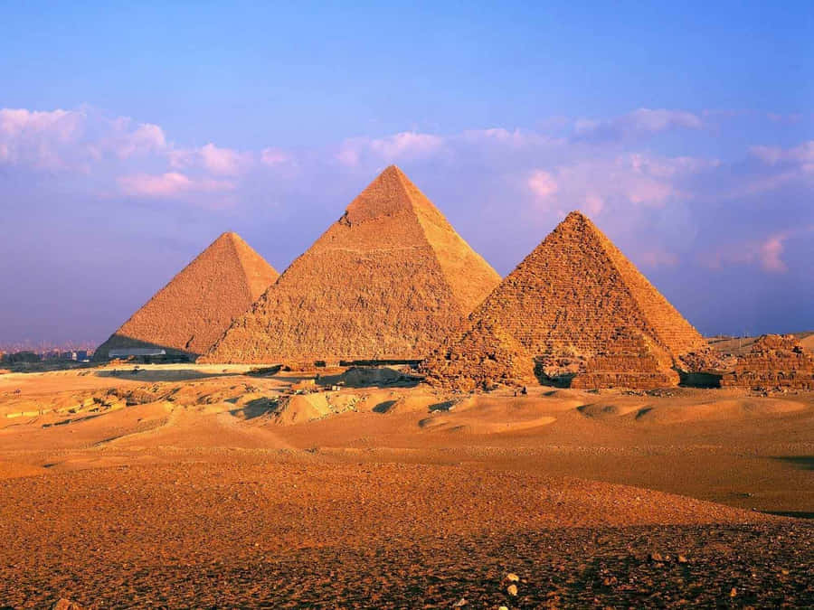 Majestic Giza Pyramids Bathed In Golden Sunset Glow Wallpaper