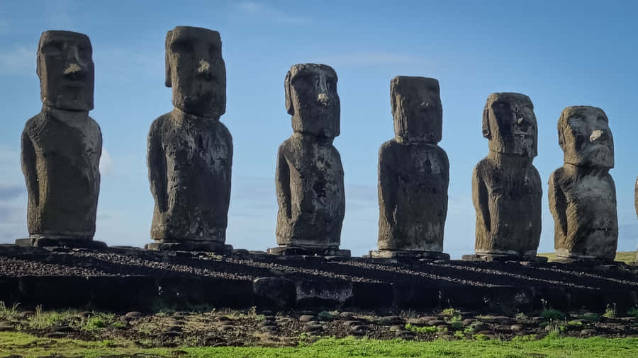 Majestic Moai Statues Cast Shadows At Sunset Wallpaper
