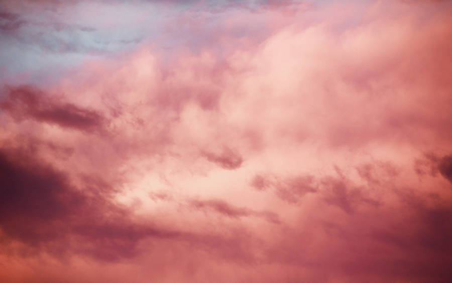 Majestic Pink Clouds Illuminated By A Soothing Sunset Wallpaper
