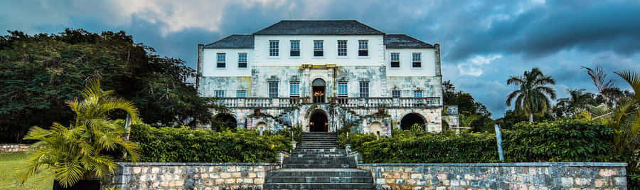 Majestic View Of Rose Hall Great House Under Cloudy Sky Wallpaper