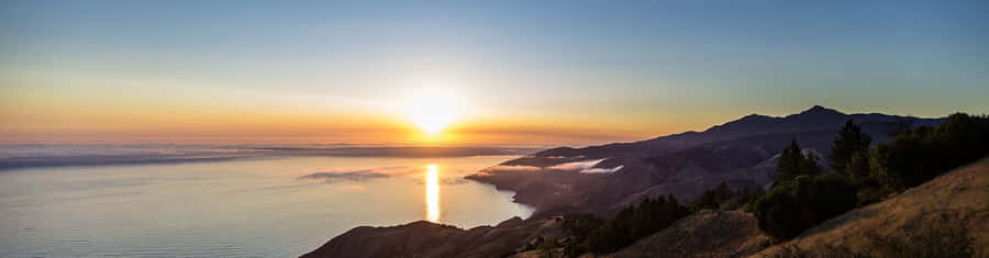 Malibu Beach At Dawn - A Picturesque Sunrise Wallpaper
