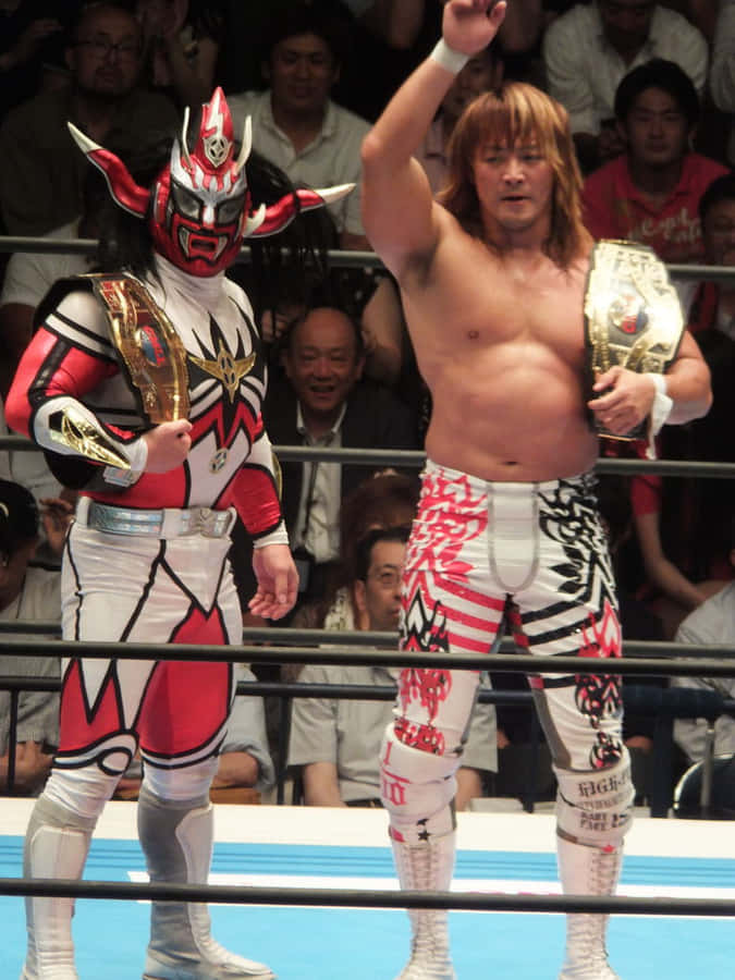 Pro Wrestlersin Ring Victory Pose Wallpaper