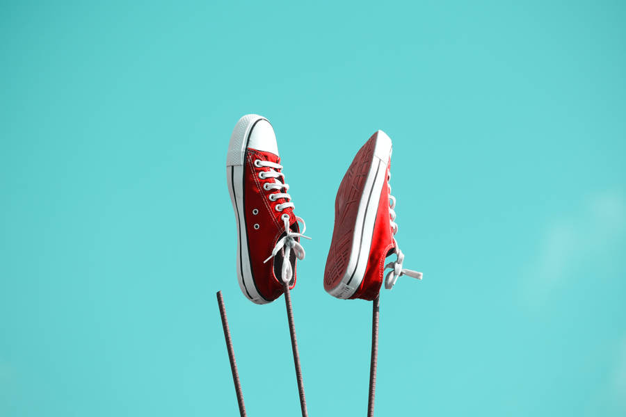 Red Converse Shoes Against Iron Bars Wallpaper