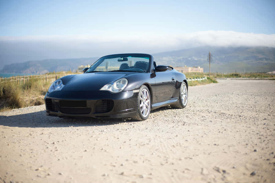 Sleek_ Black_ Convertible_ Coastal_ Road.jpg Wallpaper