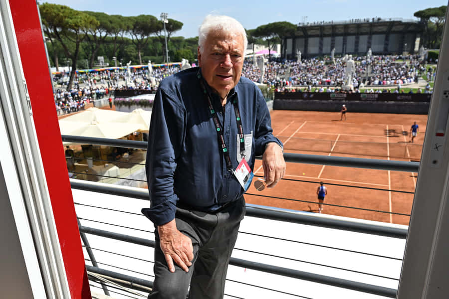 Tennis Legend Overlooking Clay Court Wallpaper