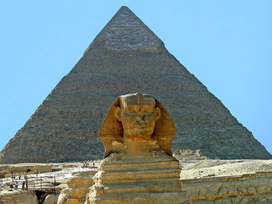 The Imposing Pyramids Of Giza And The Great Sphinx At Dusk Wallpaper