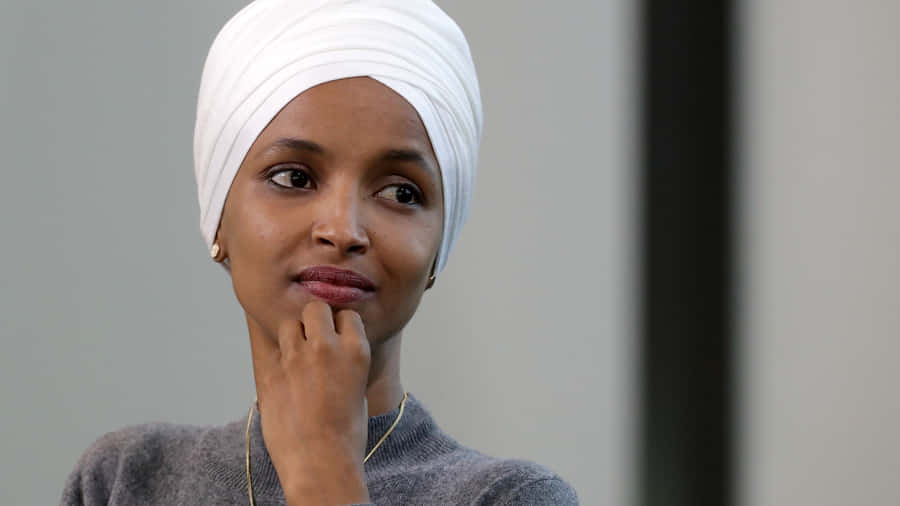 Us Representative Ilhan Omar Posing With A Contemplative Expression Wallpaper