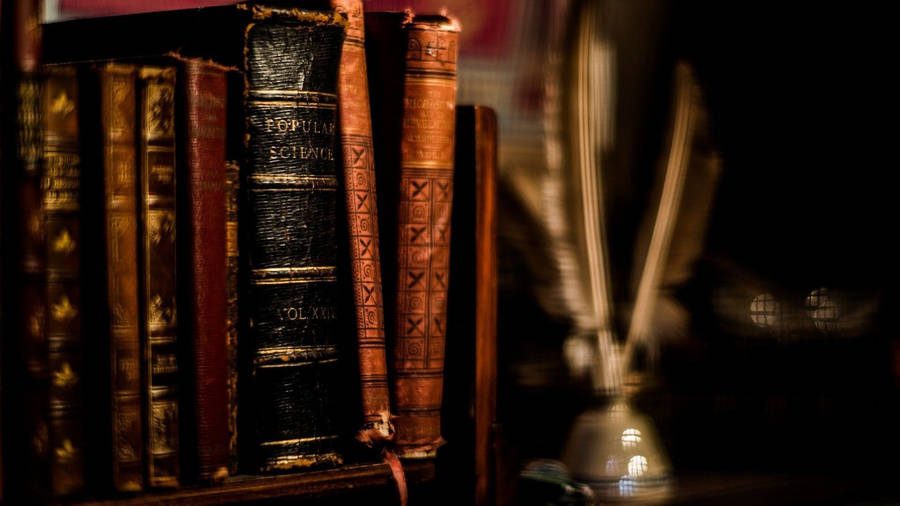 Vintage Feathered Quill On Classic Leather Book Cover Wallpaper