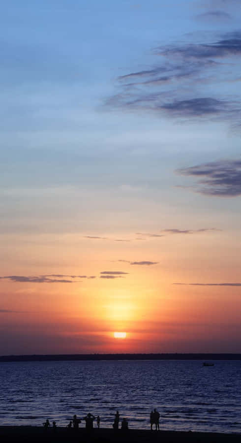 Watch The Sunset Over Picturesque Beachscape Wallpaper