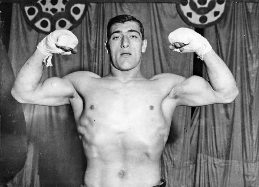 World Heavyweight Boxing Champion Primo Carnera Showcasing His Strength Wallpaper