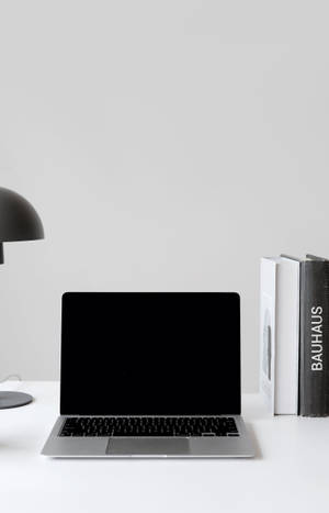 4k Black Macbook With Books Wallpaper