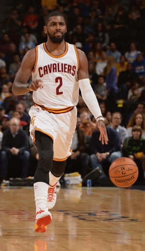 A Basketball Player Is Dribbling The Ball On The Court Wallpaper