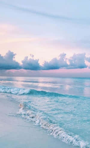 A Beach With Waves And Clouds At Sunset Wallpaper
