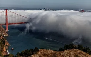 A Beautiful Work Setup Showcasing A Laptop With A Stunning View Of San Francisco In The Background Of A Window. Wallpaper