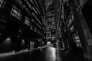 A Black And White Photo Of A City Street At Night Wallpaper