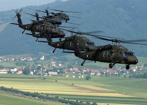 A Black Hawk Helicopter Flies Over A Clear Blue Sky Wallpaper