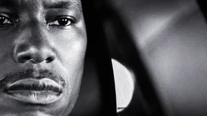 A Black Man Is Staring Out Of A Car Window Wallpaper