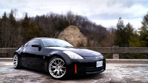 A Black Sports Car Is Parked On A Bridge Wallpaper