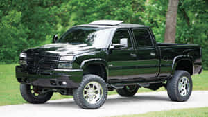 A Black Truck Is Parked On A Road Wallpaper