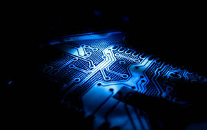 A Blue Light Shining On A Circuit Board Wallpaper