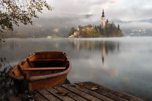 A Boat Docked At A Quay In Lake Bled Wallpaper