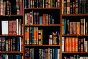 A Book Shelf With Many Books On It Wallpaper
