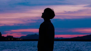 A Boy Stands Tall Against A Beautiful Purple Sky Wallpaper