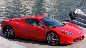 A Bright Red Ferrari Ferries Fast Along The Open Highway Wallpaper