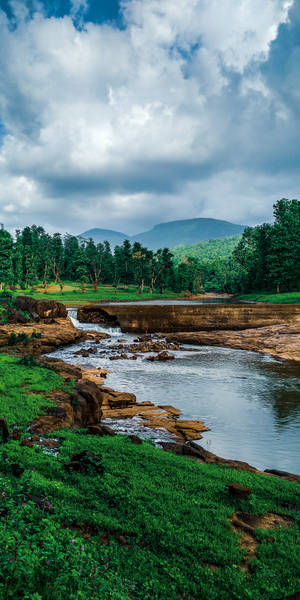 A Calming River Winds Through The Lush Green Landscape. Wallpaper