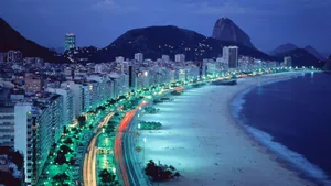 A City At Night With A Beach And Mountains Wallpaper