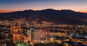 A City At Night With Mountains In The Background Wallpaper