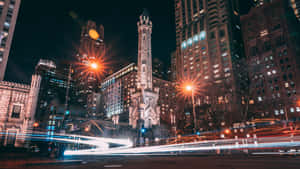 A City Street With Lights And Buildings At Night Wallpaper
