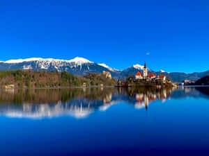 A Clear View Of The Julian Alps At Lake Bleds' Hillside Wallpaper