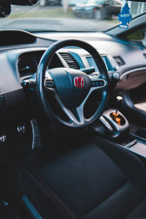 A Close-up Look At The Steering Wheel Of A Honda Car Wallpaper