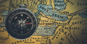 A Compass On A Map Of The World Wallpaper