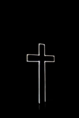 A Cross Is Lit Up In The Dark Wallpaper