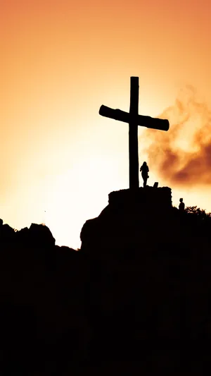 A Cross Is Silhouetted Against The Sunset Wallpaper