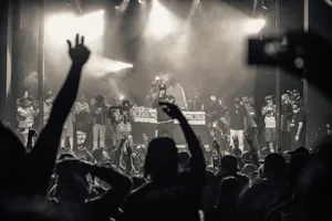 A Crowd Of People At A Concert With Their Hands Up Wallpaper