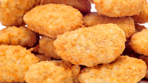 A Delicious Plate Of Golden Fried Chicken Nuggets. Wallpaper