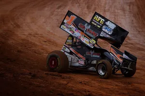A Dirt Track Race Car Driving Down A Dirt Track Wallpaper