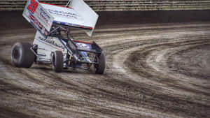 A Dirt Track Race Car Driving Down The Track Wallpaper