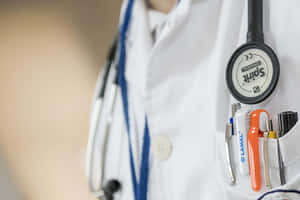 A Doctor's Coat With A Stethoscope And A Pen Wallpaper